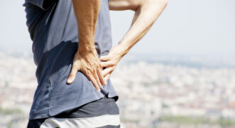 A male person, having severe lower-back pain.